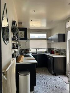eine kleine Küche mit einem Waschbecken und einem Fenster in der Unterkunft Duplex de charme en centre ville avec terrasse in Brive-la-Gaillarde
