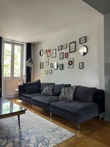 a living room with a blue couch and pictures on the wall at Duplex de charme en centre ville avec terrasse in Brive-la-Gaillarde