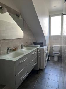 a bathroom with a sink and a washing machine at Duplex de charme en centre ville avec terrasse in Brive-la-Gaillarde