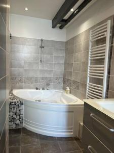 baño con bañera grande y lavamanos en Duplex de charme en centre ville avec terrasse, en Brive-la-Gaillarde