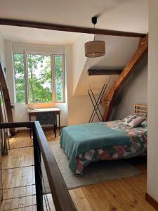 een slaapkamer met een bed in een kamer met een trap bij Duplex de charme en centre ville avec terrasse in Brive-la-Gaillarde
