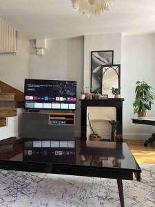 a living room with a tv and a coffee table at Duplex de charme en centre ville avec terrasse in Brive-la-Gaillarde