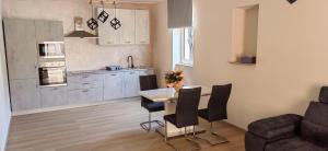 a kitchen and living room with a table and chairs at Apartman Hana 2 in Rab