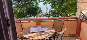 a table and chairs on a balcony with a view of the ocean at Apartman Hana 2 in Rab