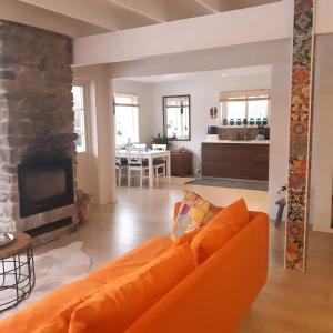 un soggiorno con divano arancione e camino di Stunning 8-Bed Cabin at lake Skagern a Finnerödja