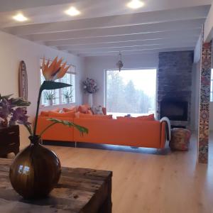 een woonkamer met een oranje bank en een tafel bij Stunning 8-Bed Cabin at lake Skagern in Finnerödja