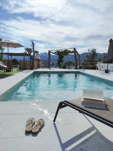 un par de sandalias sentadas junto a una piscina en Casa de campo con maravillosas vistas, bbq y piscina, en Ronda