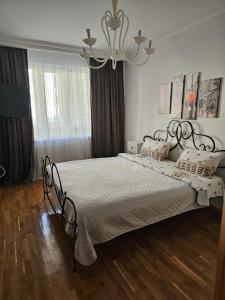 ein Schlafzimmer mit einem großen Bett mit einem Kronleuchter in der Unterkunft Negruzzi 2 bedrooms in Chişinău