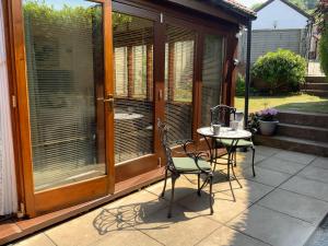 a screened in porch with a table and chairs at Whortleberry Studio B & B in Porlock