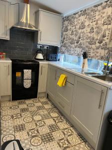 a kitchen with a sink and a stove top oven at Arely House Rooms With Shared Bathroom in Arley