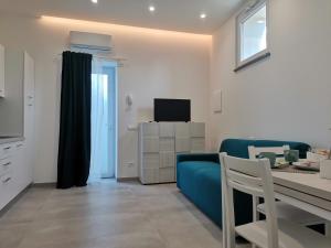 a living room with a blue couch and a table at Casa Verdemare in Ischia