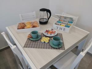 una mesa con un desayuno con pastas y tazas de café en Casa Verdemare en Ischia
