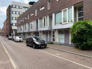 een straat met auto's geparkeerd voor gebouwen bij Hotelkamer Prinsenstraat with Free Parking in Groningen