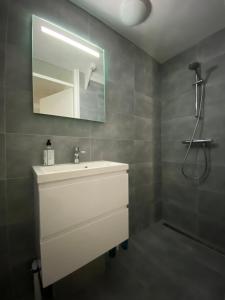 een badkamer met een witte wastafel en een spiegel bij Hotelkamer Prinsenstraat with Free Parking in Groningen