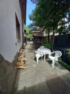 un patio con tavoli e sedie bianchi accanto a un edificio di David House a Bicaz