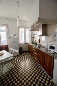 una cucina con pavimento a scacchi in bianco e nero di Apartamento do Arquinho I - by VinteOito ad Amarante