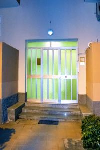 una puerta delantera de un edificio con escaleras y una ventana en Lilla House, en Furci Siculo