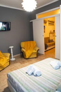 1 dormitorio con cama, sofá y TV en Lilla House, en Furci Siculo