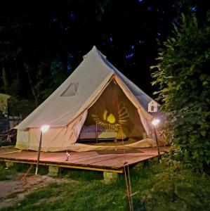 Honeymoon Zelt im Ruhrpott في أوبرهاوزن: خيمة تايبي مع شرفة خشبية في الليل