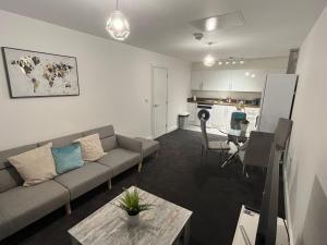 ein Wohnzimmer mit einem Sofa und einem Tisch in der Unterkunft Nottingham Brand New 1BR Apt w/ Full Kitchen City in Nottingham