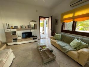 ein Wohnzimmer mit Sofa und Fernseher in der Unterkunft Porto Hydra - Villa Mirani in Ermioni