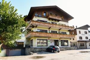 a building with a car parked in front of it at Guesthouse Rosengarten in Dobbiaco