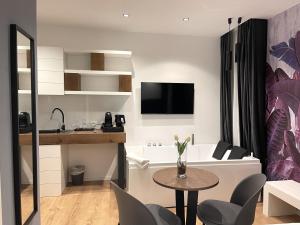 a small living room with a table and a kitchen at Residenze Chamur- Grattacielo in Palermo