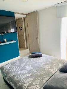 1 dormitorio con 1 cama grande y pared azul en Amplio e iluminado Apartamento, en Yopal