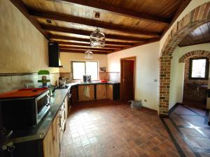 a large kitchen with wooden floors and a wooden ceiling at Villa Mbolatsara in Nosy Be