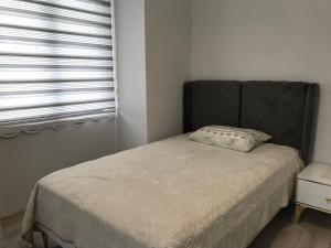 um quarto com uma cama com uma cabeceira preta e uma janela em MİRAY SUİTE VİLLA em Trebizonda