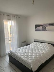 a bed in a bedroom with a picture on the wall at Appartement 2 pièces in Fréjus