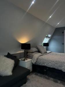 1 dormitorio con 2 camas y mesita de noche con lámpara en Dyserth Waterfalls apartment, en Dyserth