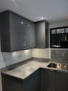 a kitchen with black cabinets and a sink at Dyserth Waterfalls apartment in Dyserth