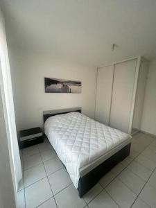 a bedroom with a bed in a white room at Appartement 2 pièces in Fréjus