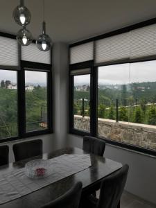 uma sala de jantar com mesa, cadeiras e janelas em MİRAY SUİTE VİLLA em Trebizonda