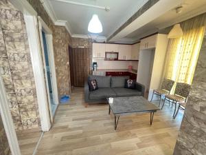 uma sala de estar com um sofá e uma mesa em kızıl apart em Buca