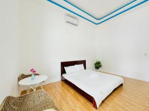 a bedroom with a bed and a table at Ben's House 2 in Quy Thượng