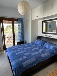 Schlafzimmer mit einem großen Bett mit blauer Decke in der Unterkunft Porto Hydra - Villa Mirani in Ermioni + 41 Fotos