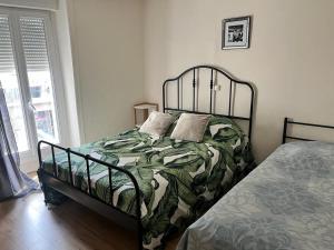 a bedroom with a bed with a green comforter at Appartement familial le Tanis in Pontorson