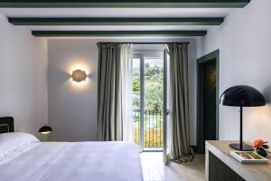 a bedroom with a bed and a large window at Donna Carmela Resort & Lodges in Riposto