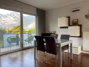 a dining room with a table and chairs and a balcony at La Dolce Vita Arco in Arco