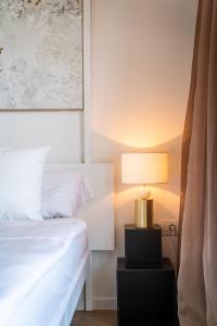 ein Schlafzimmer mit einem Bett und einer Lampe auf einem Nachttisch in der Unterkunft Villa Maria Boutique Apartment St Pauls in Appiano sulla Strada del Vino