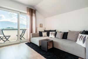 ein Wohnzimmer mit einem Sofa und einem großen Fenster in der Unterkunft Villa Maria Boutique Apartment St Pauls in Appiano sulla Strada del Vino