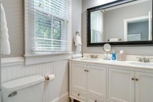 a white bathroom with a sink and a mirror at Wilmington Vacation Rental Close to Riverwalk! in Wilmington +21 photos