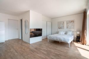 a white bedroom with a bed and a mirror at Villa Maria Boutique Apartment St Pauls in Appiano sulla Strada del Vino