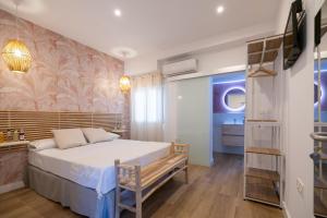 a bedroom with a large bed and a bathroom at Hostal Royal Bliss in Punta Umbría