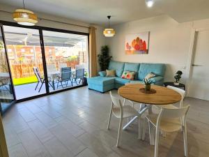 a living room with a blue couch and a table at Terrace Mares de Benajarafe - Alojamientos La Torre in Benajarafe