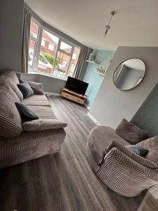 a living room with a couch and a mirror at Fabulous 3bed off street parking in Stafford