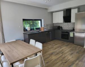 a kitchen with a wooden table and white chairs at New House for Vip's in Słubice