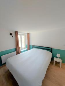 ein weißes Bett in einem Zimmer mit Fenster in der Unterkunft ° Appart 4 - Lunéville centre ° in Lunéville